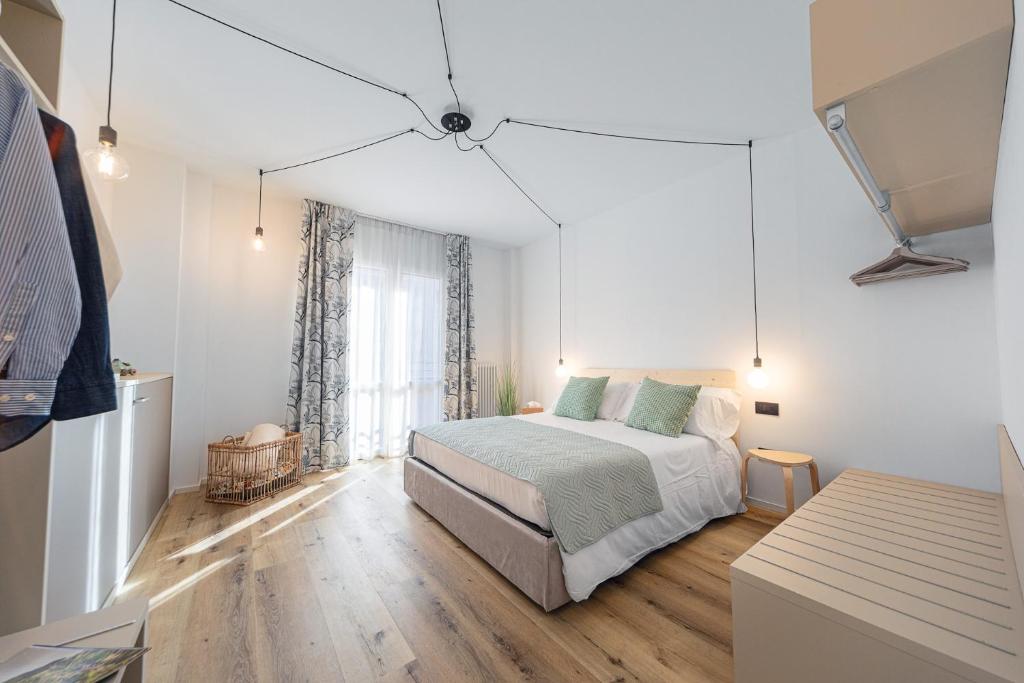 a white bedroom with a bed and a window at Aosta Centre Apartments - Battaglione 10 in Aosta