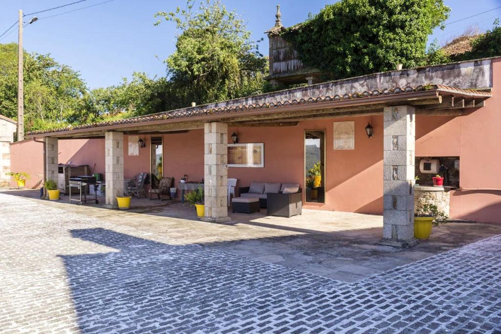 a pink house with a patio and a brick road at Spacious House with Mountain View in Carboeiro de Francia in Martije