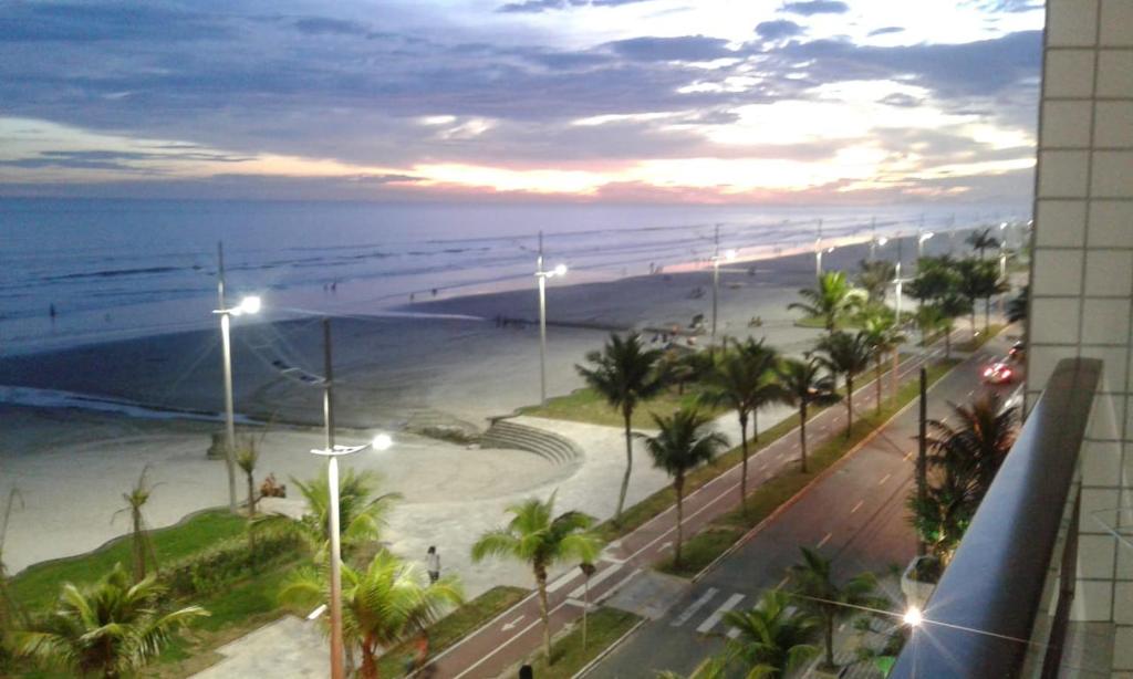 a view of the beach from a building with street lights at Lindo apartamento de frente ao mar in Praia Grande
