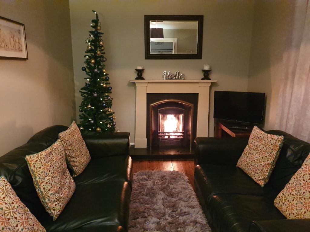 a living room with a christmas tree and a fireplace at Jack's Place Beautiful 3-Bed House Donegal in Stranorlar