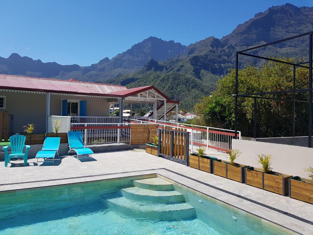 a house with a swimming pool with mountains in the background at VILLA GRONDIN in Cilaos
