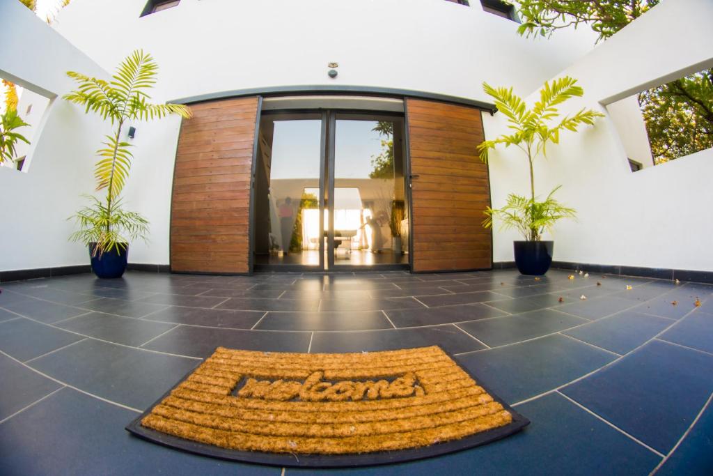 una hall con un tappetino di benvenuto di fronte a un edificio di Villa Ilo Majunga a Mahajanga