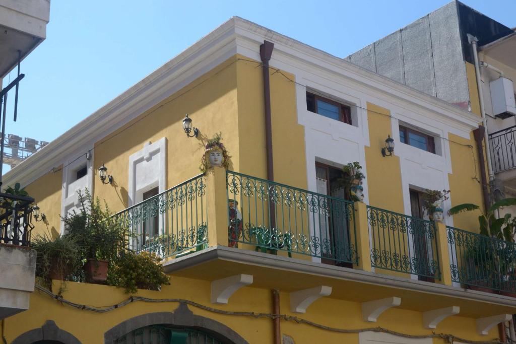 Edificio amarillo y blanco con balcón en Villa Felice, en Giardini Naxos