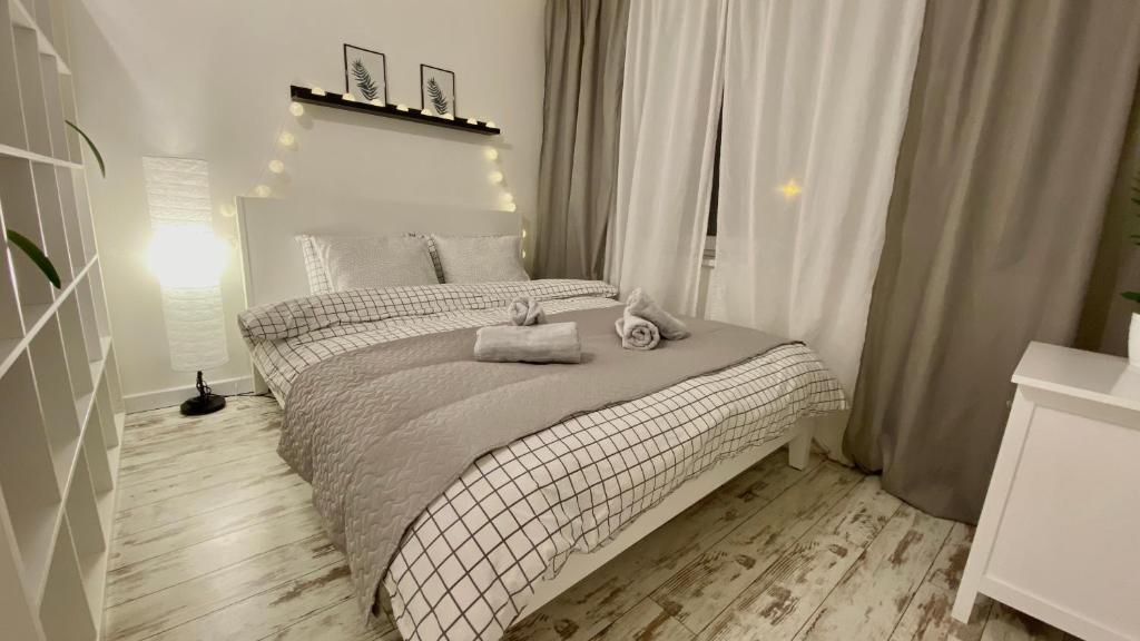 ein Schlafzimmer mit einem Bett mit zwei Handtüchern darauf in der Unterkunft Cosy&White apartment in Daugavpils in Daugavpils