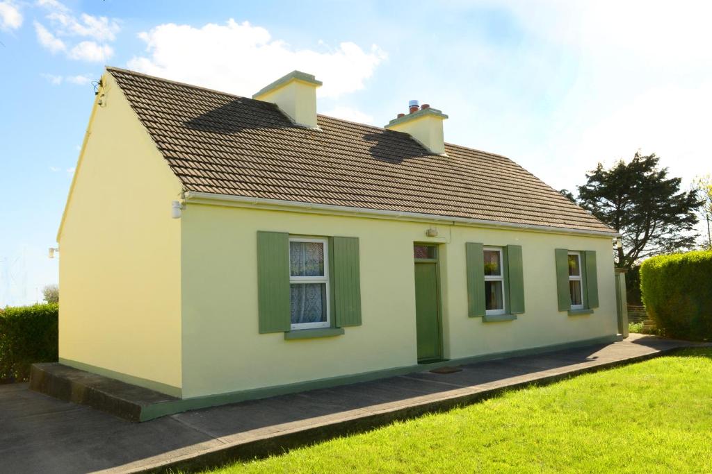 a small yellow house with green shutters at 4-Bed Cottage in Co Galway 5 minutes from Beach in Inverin