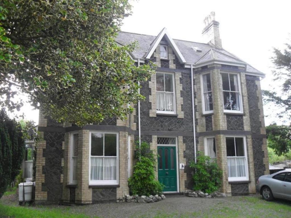 a brown brick house with a green door at Plas Dorothea in Nantlle