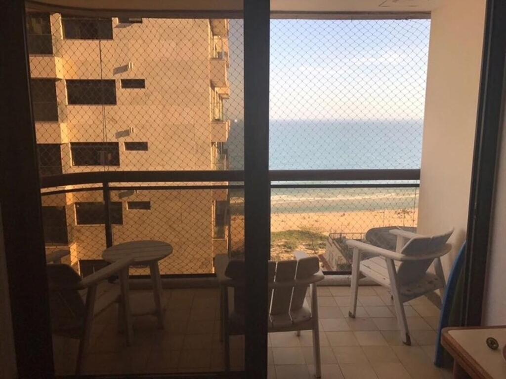 a room with a window with a view of the beach at Apart Quadra Praia de Ipanema in Rio de Janeiro