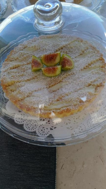 a cake on a glass plate with fruit on it at FONTEblu B&B in Polignano a Mare