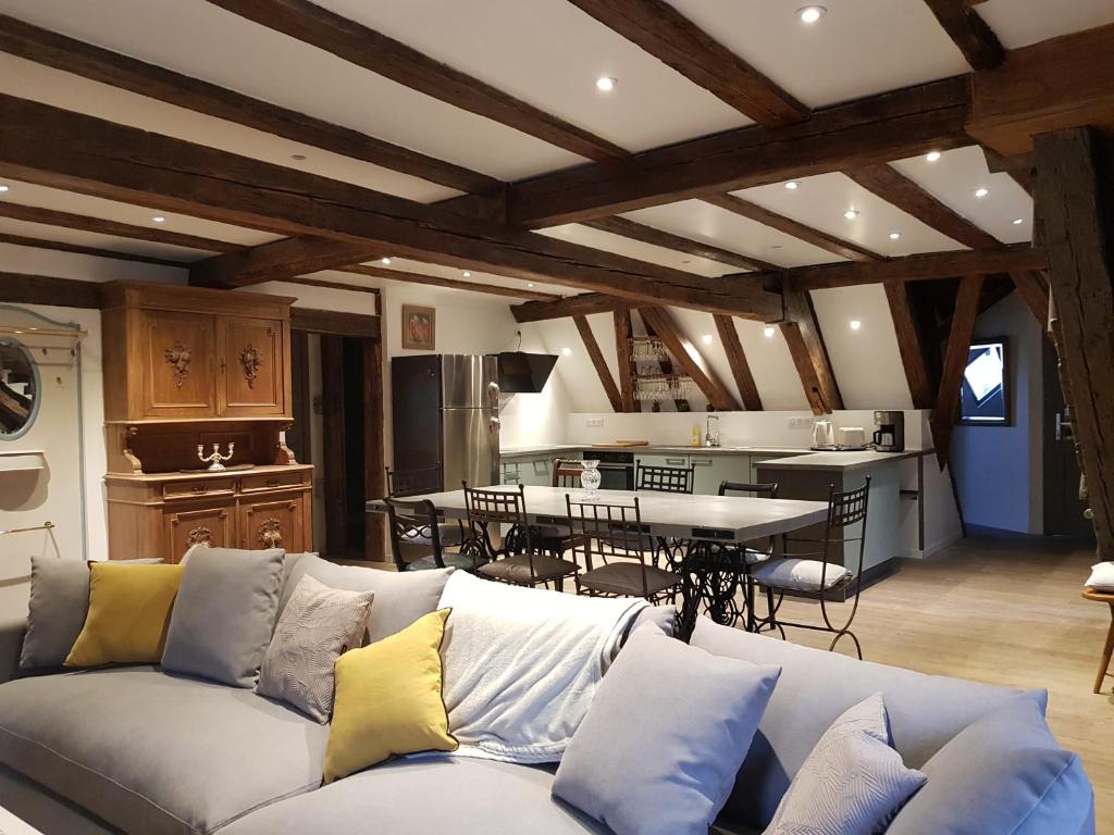 a living room with a couch and a kitchen at à l'orée du bois in Riquewihr