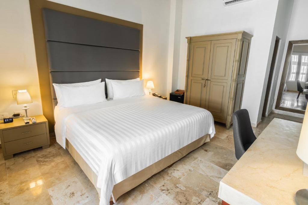 Postel nebo postele na pokoji v ubytování GHL Collection Armería Real Hotel