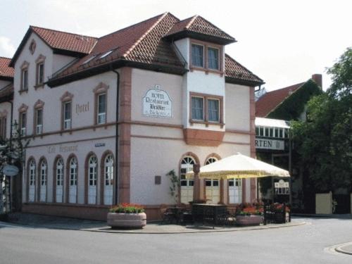 ein großes Gebäude mit einem Schirm davor in der Unterkunft Hotel Brößler in Stockstadt am Main