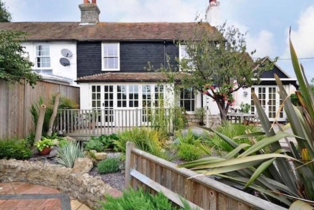 a house with a fence and a garden at Luxury Country Cottage in Smeeth