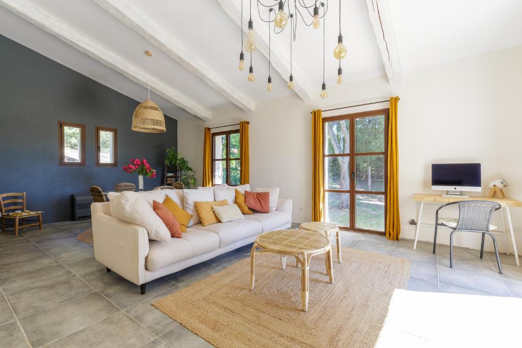 a living room with a white couch and a table at Lodge de charme 135m2 avec piscine dans les vignes AOC Bandol à 15 min des plages et du circuit Paul Ricard F1 in Le Beausset