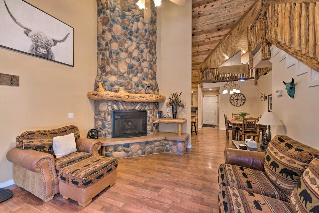 - un salon avec une grande cheminée en pierre dans l'établissement Spacious Pinetop Country Club Cabin with Deck!, à Pinetop-Lakeside