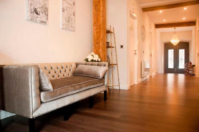Una sala de estar con un sofá y suelo de madera. en Hostal Jardin Secreto, en Santander