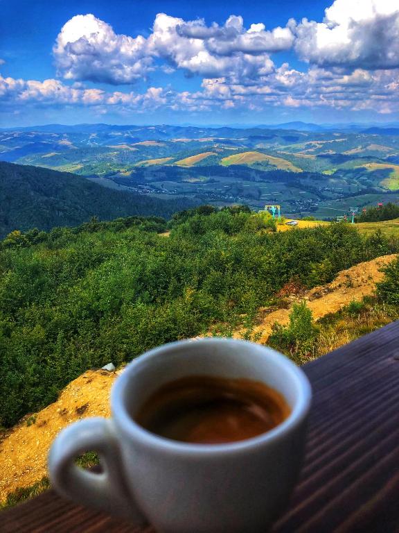 a cup of coffee sitting on top of a table at Вершина in Pilipets