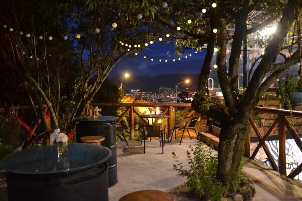 un patio con un árbol y una mesa con luces en Supertramp Hostel Cusco, en Cusco