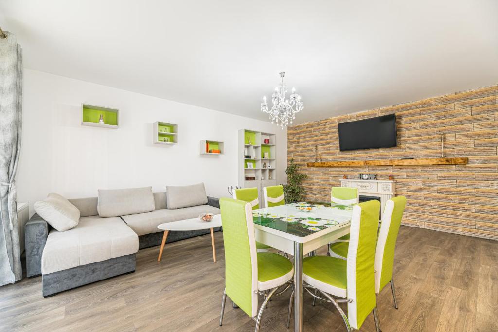 een woonkamer met een tafel en gele stoelen bij Apartament 2 camere Narcis in Braşov