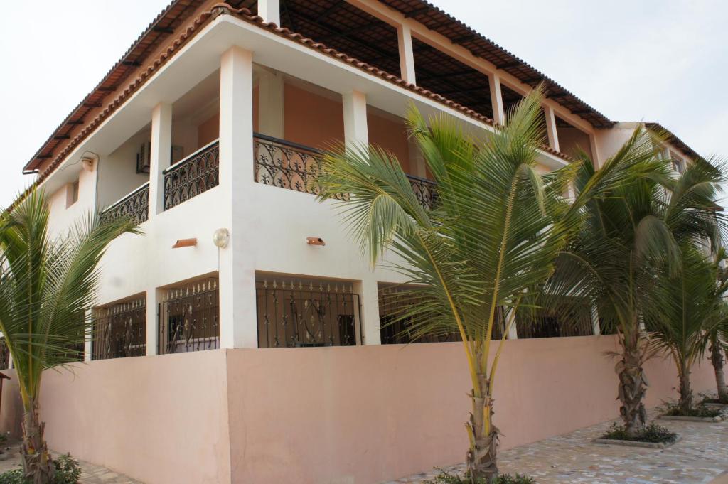 un edificio con palmeras delante en Villa Rosa en Dakar