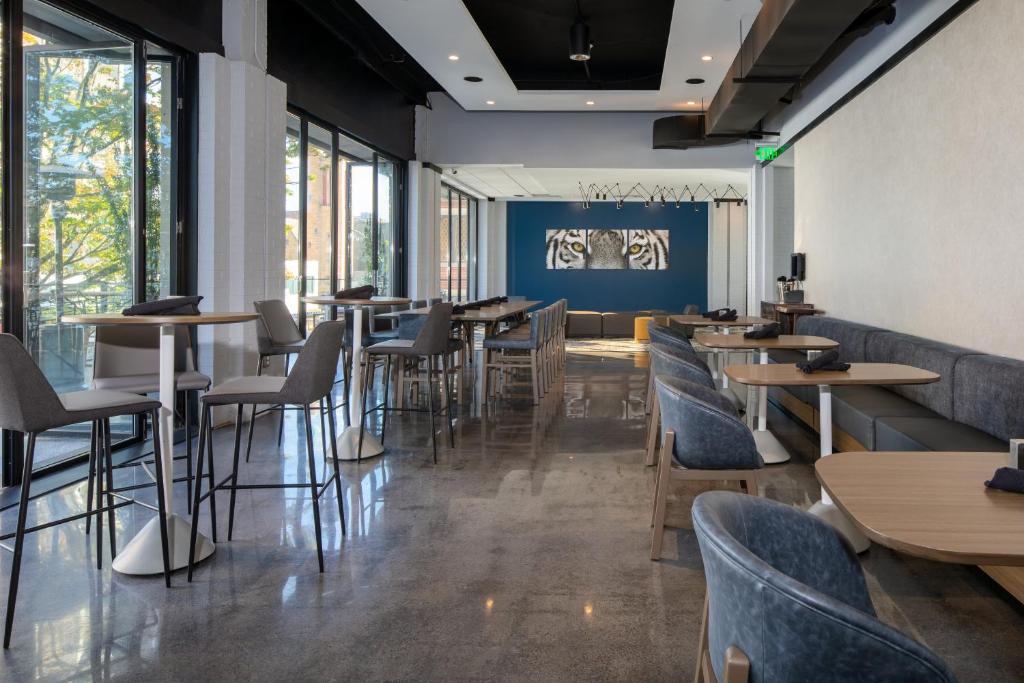 a restaurant with tables and chairs and windows at Hotel Indigo Chattanooga - Downtown by IHG in Chattanooga