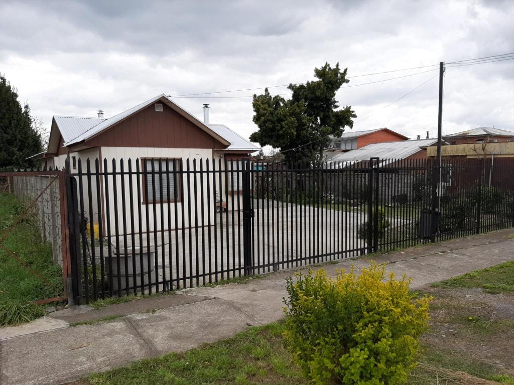 Pitrufquén的住宿－Cabaña centro Pitrufquen，房屋前的黑色围栏