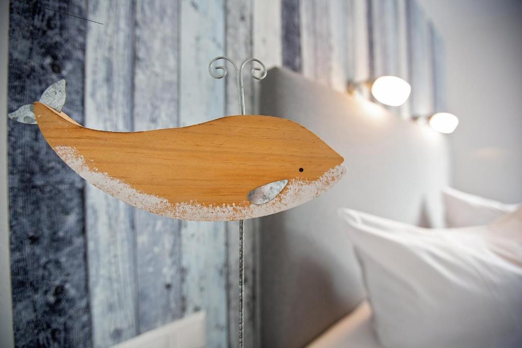 una cabeza de pájaro de madera en el lateral de una cama en Appartements Hafen 31, en Wittdün