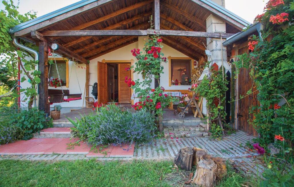 ein Haus mit einer Veranda mit Blumen darauf in der Unterkunft KUĆA ZA ODMOR "DVA SRCA" in Čeminac