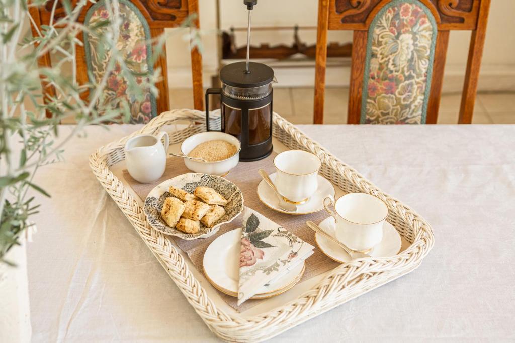 a tray with cups and plates of food on a table at Guinea Fowl House in Kommetjie