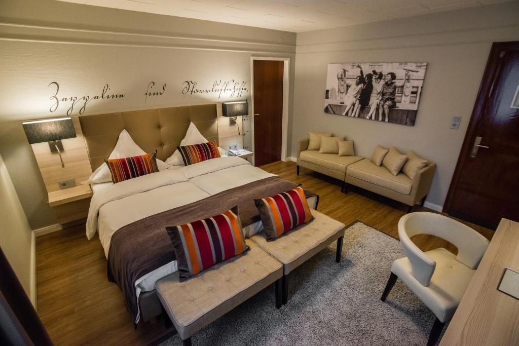 Hotel Zum Zeppelin Hamburg في هامبورغ: غرفة نوم بسرير كبير وأريكة