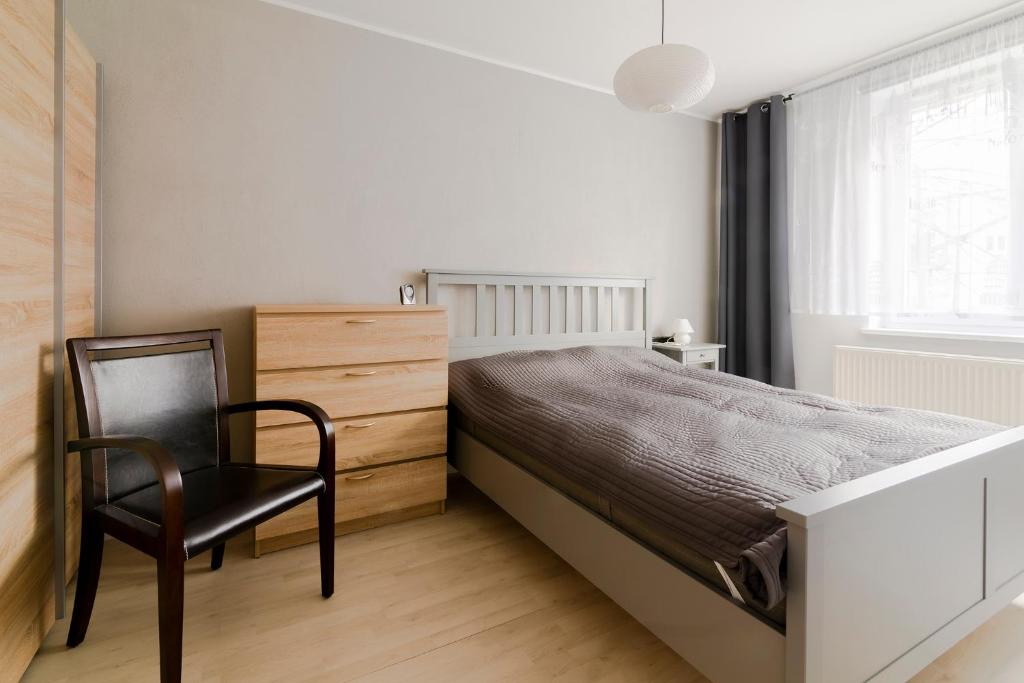 um quarto com uma cama, uma cadeira e uma janela em Good Place em Gdynia