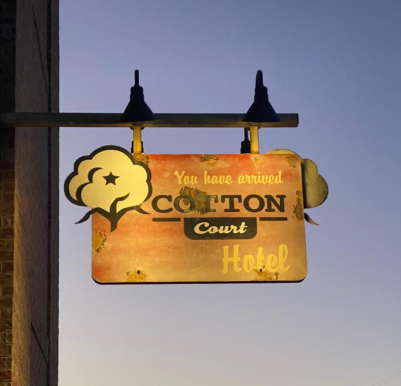 a sign for a coronation court hotel hanging on a wall at Cotton Court Hotel, by Valencia Hotel Collection in Lubbock