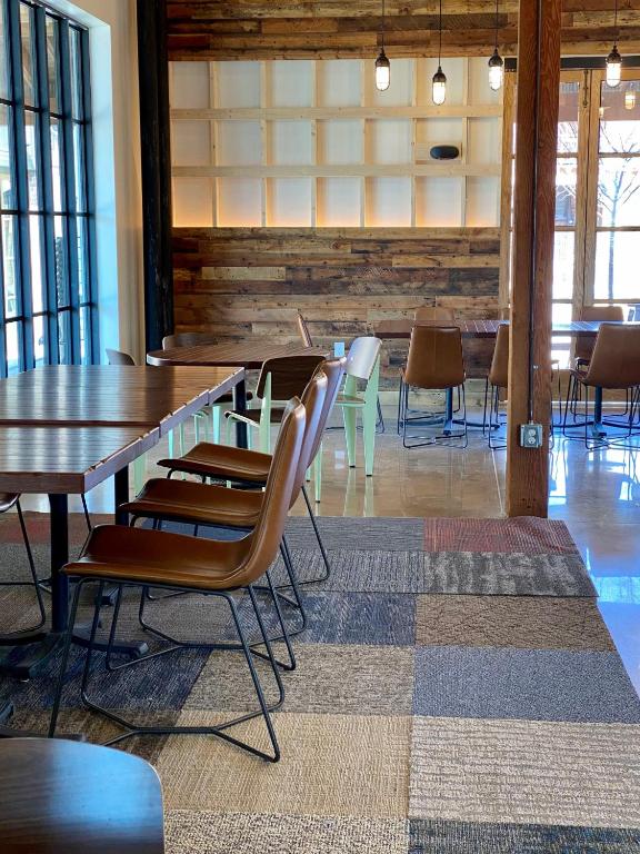 a dining room with a table and chairs and windows at Cotton Court Hotel, by Valencia Hotel Collection in Lubbock