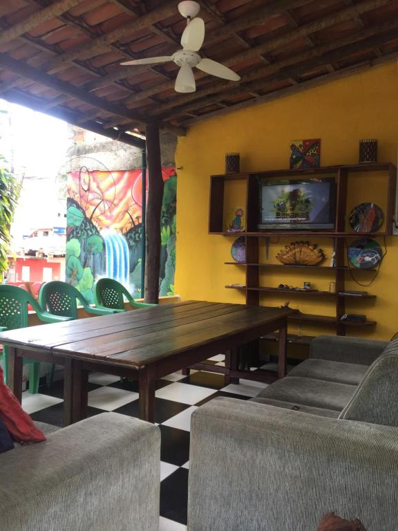 sala de estar con mesa de madera y sillas en BANANAS HOSTEL, en Itacaré