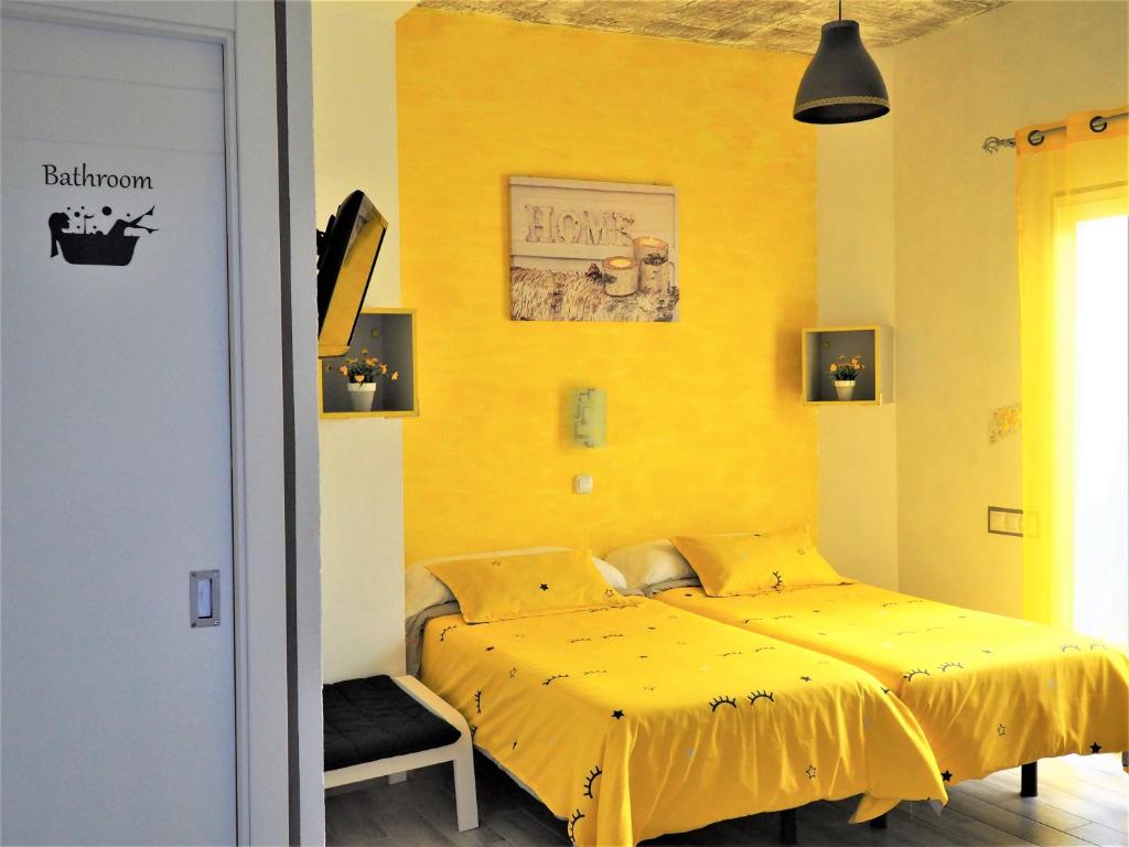 a yellow bed in a room with a yellow wall at La Siezzzta in Jerez de la Frontera