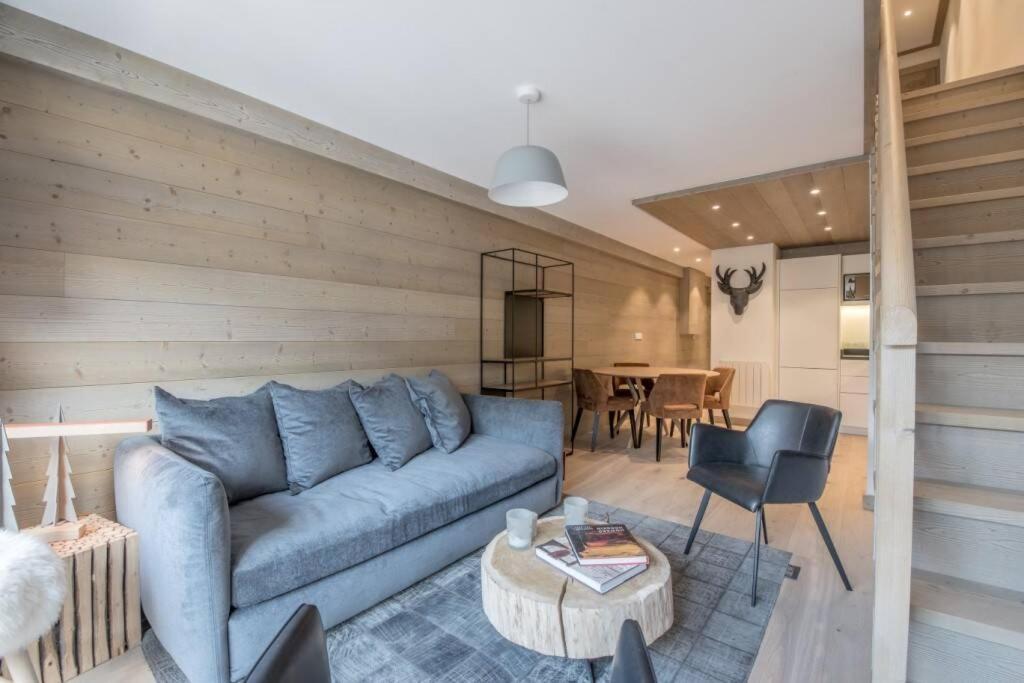 un soggiorno con un divano blu e un tavolo di Le lodge des Cîmes, Méribel Centre, Magnifique duplex cosy a Méribel