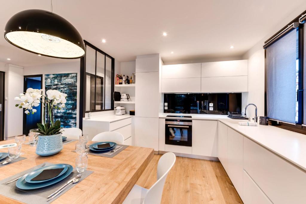 - une cuisine avec une table en bois et des placards blancs dans l&#39;établissement Les Sorbiers - Apartment 2 bedrooms top floor - parking &amp; terrace, à Annecy