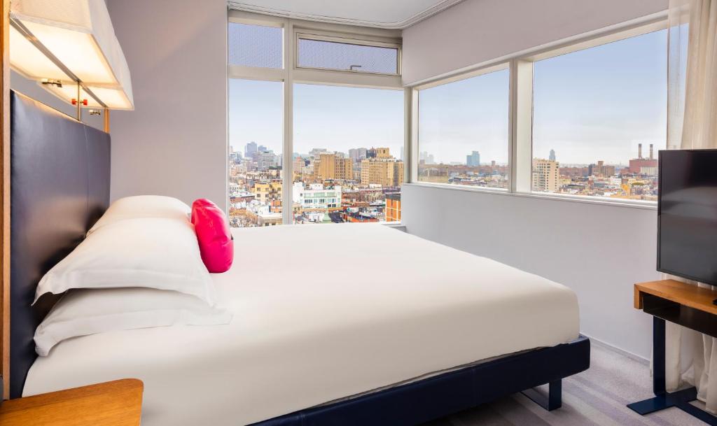 a bedroom with a bed and a large window at The Standard - East Village in New York