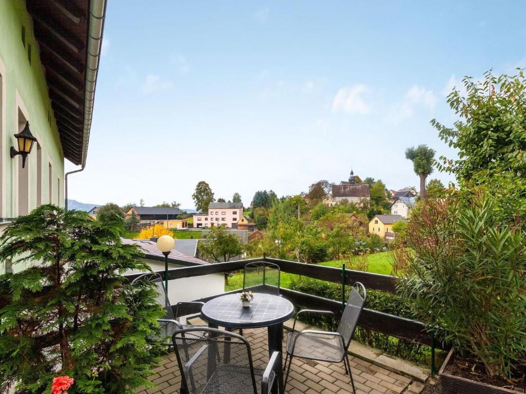 eine Terrasse mit einem Tisch und Stühlen auf dem Balkon in der Unterkunft Apartment in Lichtenhain with mountain views in Lichtenhain