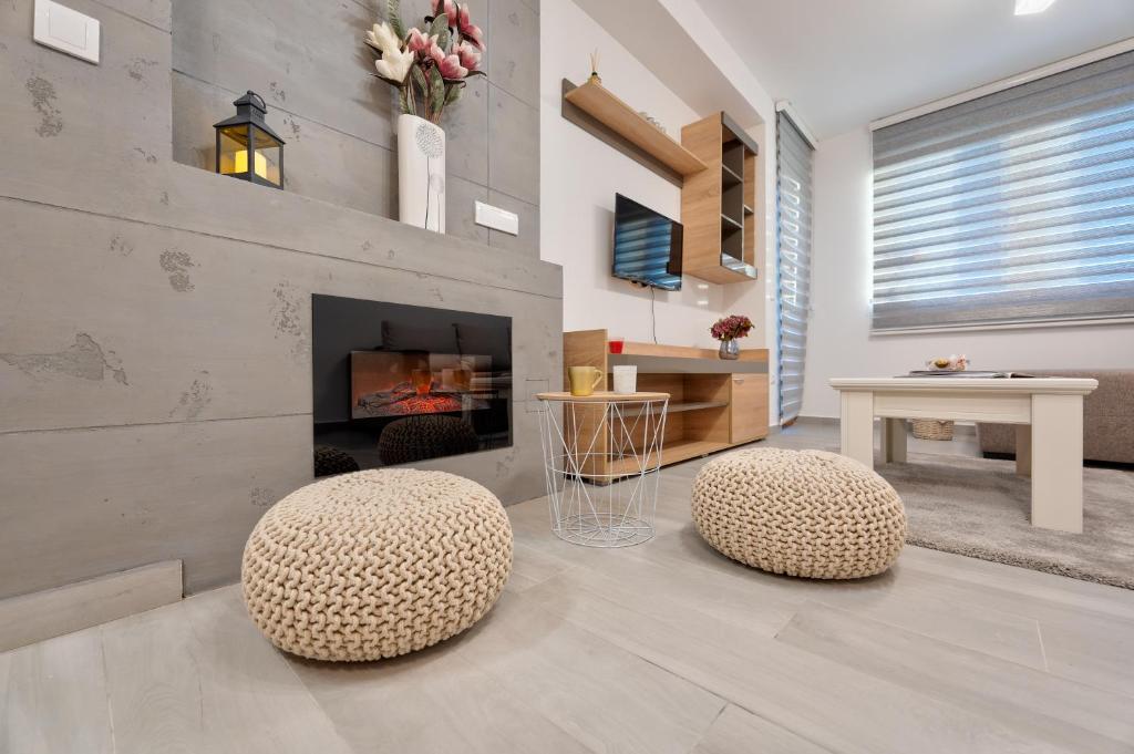 - un salon avec deux tabourets et une cheminée dans l'établissement Apartman Aroma Lux 25, à Zlatibor