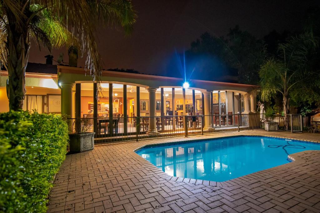 a building with a swimming pool at night at Hutten Heights Lodge by Ilawu in Newcastle