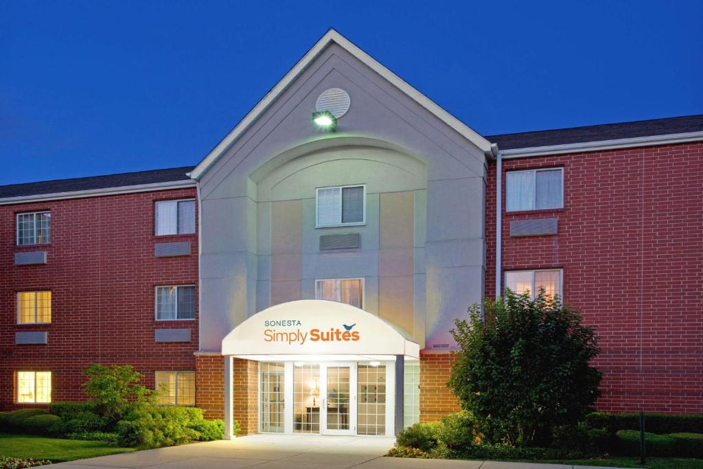 a large brick building with a study suites sign in front at Sonesta Simply Suites Chicago Naperville in Warrenville