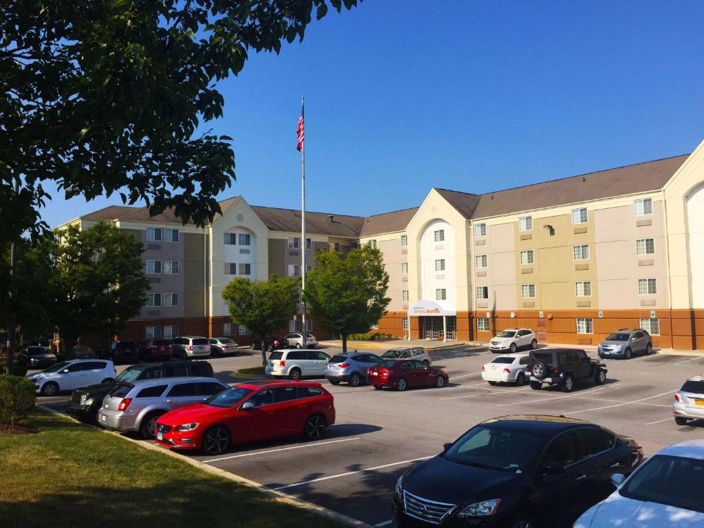 a large building with cars parked in a parking lot at Sonesta Simply Suites Baltimore BWI Airport in Linthicum Heights