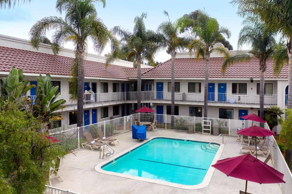 an image of a pool at a hotel with palm trees at Motel 6-Santa Maria, CA - North in Santa Maria