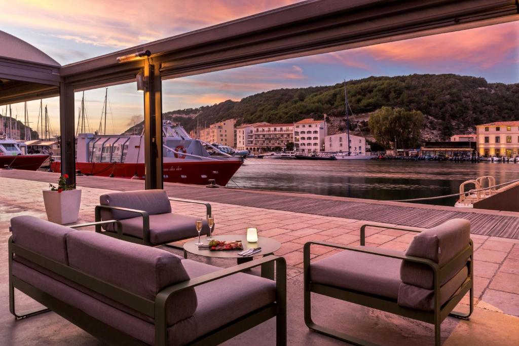 a balcony with a view of a river and a boat at Best Western Hotel du Roy d'Aragon in Bonifacio