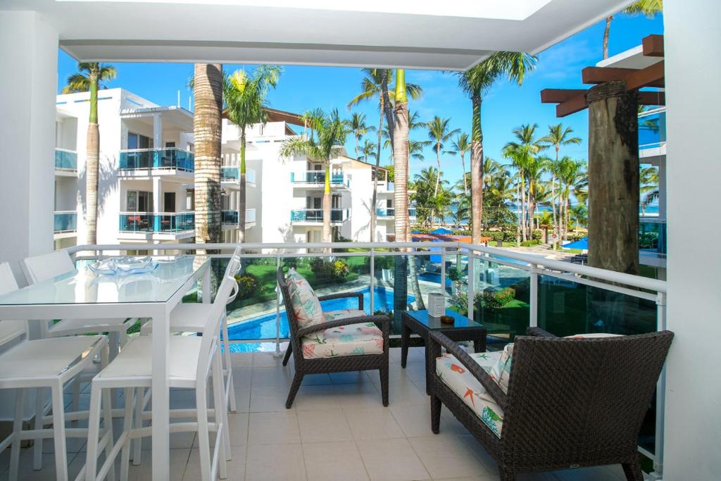 uma varanda com uma mesa e cadeiras e uma piscina em Palmeraie Terrenas beach apartamento em Las Terrenas