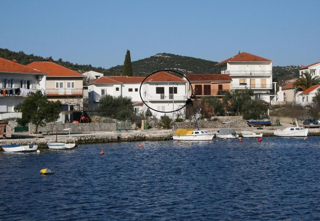 um grupo de barcos em uma massa de água com edifícios em Apartments Jere - 30 m from beach em Vinišće