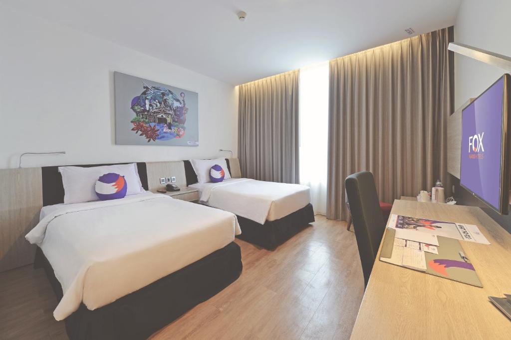 Postel nebo postele na pokoji v ubytování FOX Hotel Pekanbaru