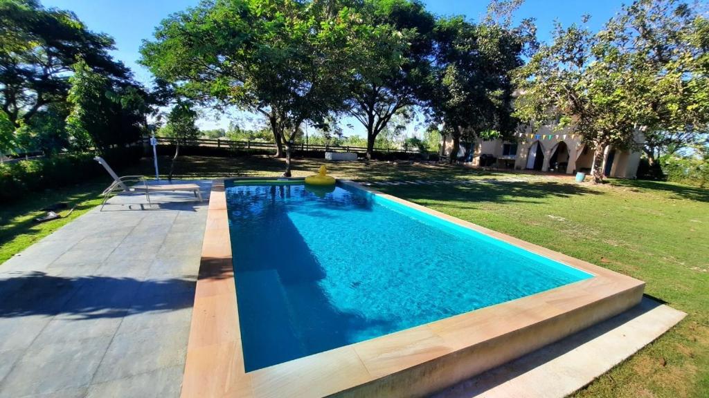 a swimming pool in a yard with trees in the background at Kampu Nature Pool Villa Rayong in Rayong