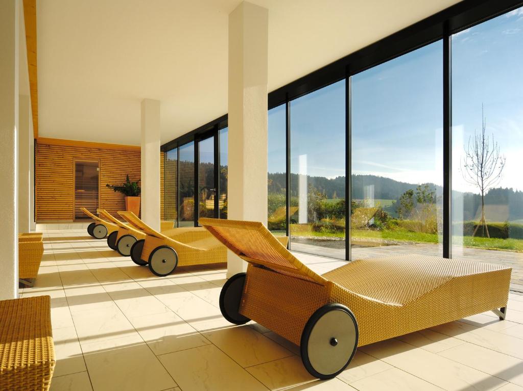 a row of beds in a room with large windows at Wellnesshotel Linde in Sulzberg