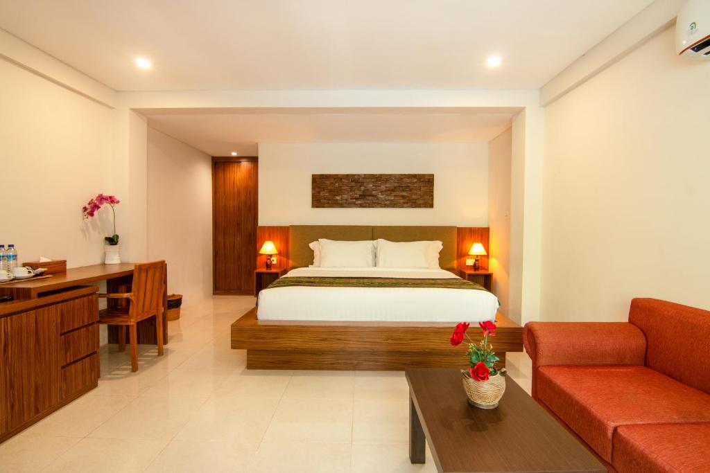 een hotelkamer met een bed en een bank bij Diva Lombok Resort in Senggigi 